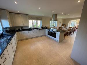 a large kitchen with white cabinets and a kitchen island at Stocks Lane Cottage in Welshampton