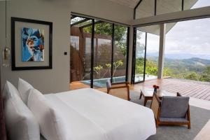 a bedroom with a white bed and a large window at Andriyala in Haputale