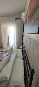 a bed with white pillows in a bedroom with a window at Sleep and Travel in Focene