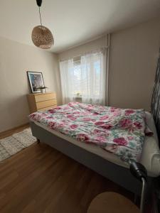 ein Schlafzimmer mit einem Bett mit einer geblümten Bettdecke in der Unterkunft Linjuri in Varkaus