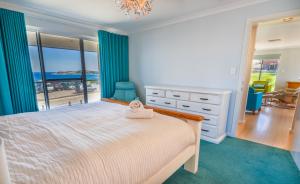 a bedroom with a bed with a view of the ocean at West Beach House in Esperance