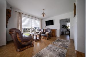 a living room with leather chairs and a table at Szczyt i Sosna in Krauszów