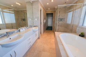 a bathroom with two sinks and a shower at West Beach House in Esperance +25 photos