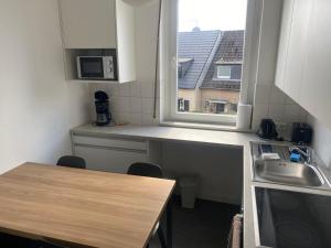 a small kitchen with a sink and a window at Stefans Apartments B - 20 min bis DD Messe und Flughafen inkl Parkplatz in Willich