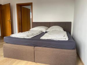a bed with two pillows on it in a room at Stefans Apartments B - 20 min bis DD Messe und Flughafen inkl Parkplatz in Willich