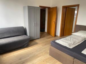 a bedroom with a bed and a couch in it at Stefans Apartments B - 20 min bis DD Messe und Flughafen inkl Parkplatz in Willich