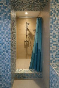 a bathroom with a shower with a blue shower curtain at Midi station in Brussels