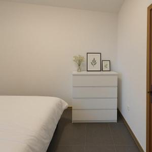 a bedroom with a white bed and a dresser at Midi station in Brussels