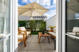 a patio with a table and an umbrella at Le Victoria Garden Disneyland Paris 10 pers in Serris +37 photos