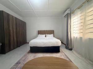 a bedroom with a bed and a large window at Destiny Executive Apartments in Solwezi