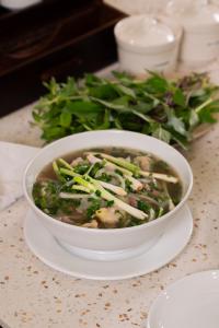 a bowl of soup on a plate on a table at APEC WANDER HOTEL - Near Pink Church in Ho Chi Minh City