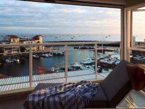 a room with a view of a marina from a window at Harbour Club in St Francis Bay +4 photos
