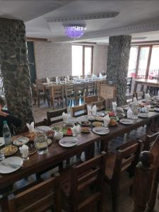 a long wooden table with plates of food on it at Hotel Tekla in Ushguli