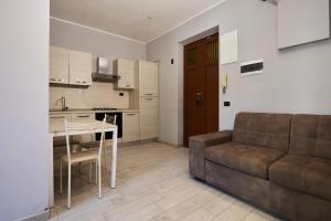 a living room with a couch and a table and a kitchen at Hotel Galimberti in Turin +73 photos