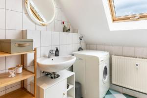 a bathroom with a sink and a washing machine at Komfortable 3-Zimmer-Fewo in Sonneberg