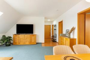 a living room with a flat screen tv on a wall at Komfortable 3-Zimmer-Fewo in Sonneberg