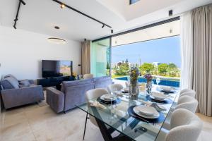 a dining room with a glass table and chairs at MITO Seaview by Serbellas in Kissonerga