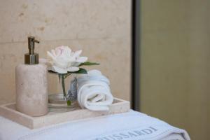 a bathroom counter with a towel and a vase of flowers at MITO Seaview by Serbellas in Kissonerga +6 photos