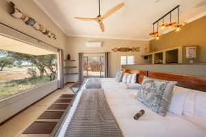a living room with a couch and a large window at Okonjima Plains Camp in Otjiwarongo