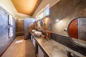 a bathroom with two sinks and a mirror at Okonjima Plains Camp in Otjiwarongo +27 photos