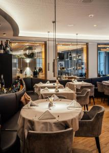 a restaurant with tables and chairs and a bar at Aktiv & Genusshotel Lodenwirt in Vandoies