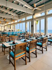 a dining room with tables and chairs and the ocean at Ally Beach Boutique Hotel Hoian in Hoi An