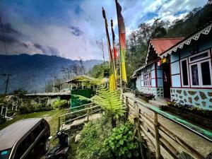 a car parked next to a house and a fence at Green Haven in Kalimpong