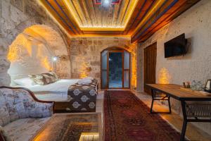 a bedroom with a bed and a desk in a room at Tyana Cave House in Nar