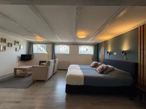a bedroom with a bed and a chair and windows at Bed and Breakfast de Salix in Hitzum