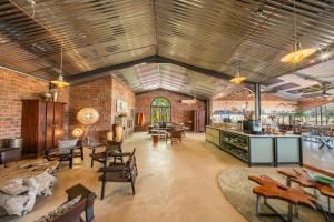 a large room with tables and chairs and brick walls at Okonjima Plains Camp in Otjiwarongo