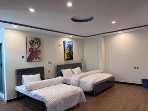 a bedroom with two beds and a ceiling at Stay O'clock Hotel Skardu in Skardu