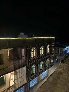 a building with illuminated windows at night at Stay O'clock Hotel Skardu in Skardu +12 photos