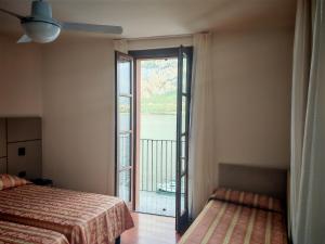 a room with two beds and a large window at Hotel Bellavista Valmadrera in Valmadrera