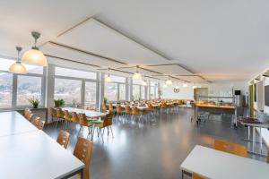 a dining room with tables and chairs and windows at Jugendherberge Bad Urach in Bad Urach +15 photos