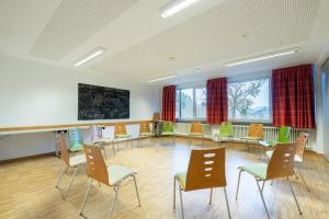 a waiting room with chairs and a chalkboard at Jugendherberge Bad Urach in Bad Urach
