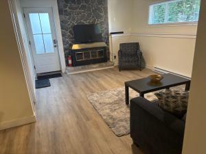 a living room with a tv and a couch and a table at Private Guest Suite In Colwood in Colwood