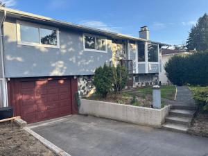 a house with a garage and a red garage door at Private Guest Suite In Colwood in Colwood