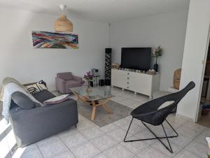 a living room with a couch and a tv at Havre de paix in La Celle-sous-Gouzon