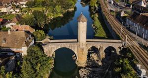 an old bridge over a river next to a city at Havre de paix in La Celle-sous-Gouzon