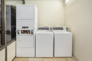 three white refrigerators sitting in a room at Days Inn by Wyndham Valdosta/Near Valdosta Mall in Valdosta