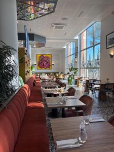 a restaurant with tables and chairs and windows at Dali Hôtel Montauban in Montauban