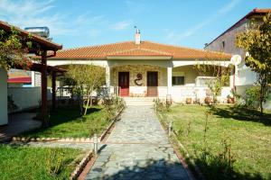 a house with a red door and a walkway at Myrtus House in Kato Loutraki