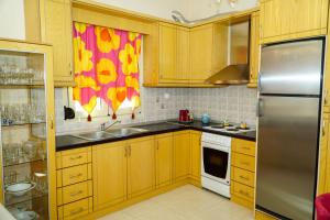 a kitchen with wooden cabinets and a stainless steel refrigerator at Myrtus House in Kato Loutraki