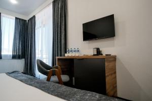 a hotel room with a bed and a television on the wall at Hotel Urban Bliss in Tbilisi City