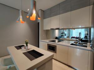 a kitchen with white cabinets and a counter top at Soho Suites Kualalampur by homestay klcc in Kuala Lumpur
