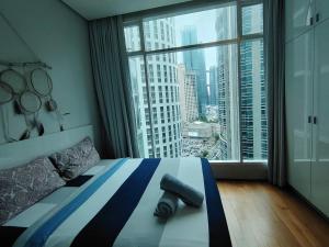 a bedroom with a bed and a large window at Soho Suites Kualalampur by homestay klcc in Kuala Lumpur