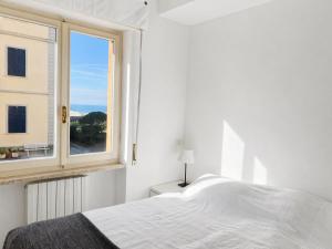 a white bedroom with a bed and a window at Vista Mare nel Corso in San Vincenzo