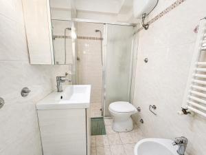 a white bathroom with a sink and a toilet at Vista Mare nel Corso in San Vincenzo