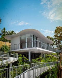 a large white building with balconies and trees at Bumi Kinar Skylight in Ubud