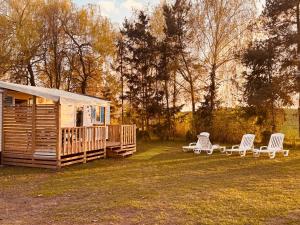 a log cabin with two chairs and a porch at Domki Na Ranczo in Gniezno